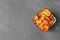 Bowl of sweet potato chips and salt on grey table, top view.