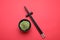 Bowl with swirl of wasabi paste and chopsticks on red background, flat lay