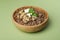 Bowl of tasty buckwheat on green background