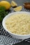 Bowl of tasty couscous on grey table, closeup