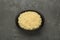 Bowl of tasty couscous on grey table, top view