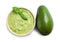 Bowl of tasty guacamole with basil and whole avocado on white background