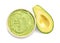 Bowl of tasty guacamole and cut avocado on white background