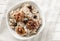 Bowl with tasty oatmeal, berries and nuts on white table