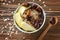 Bowl with tasty oatmeal, fruits and spices on wooden background