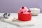 Bowl of tasty raspberry snow ice cream on table against color background.