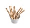 Bowl with tasty wafer roll sticks on white background.