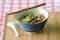 A bowl of Thai style beef noodle with spoon and chopstick.