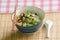 A bowl of Thai style beef noodle with spoon and chopstick.