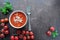 Bowl with tomato soup on wooden board