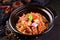 Bowl of traditional Chinese food filled with chunks of meat vegetables