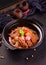 Bowl of traditional Chinese food filled with chunks of meat vegetables