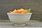 Bowl with triangle slices carrots and mint on wooden, rustic