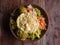 Bowl of variety of traditional vegan Sri Lankan food with different curries, papadum, rice, sambol, dal and vegetables