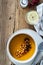 Bowl with vegan pumpkin and chickpea cream soup on wooden table, directly above