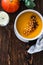 Bowl with vegan pumpkin and chickpea cream soup on wooden table, directly above