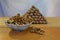 A bowl with walnut kernels and a lot of walnuts folded in the form of a pyramid