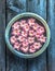 Bowl with water and flowers on blue wooden timber background