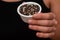 Bowl of Whole Peppercorns in a Female Hand. Gently holding a ramekin filled with assorted whole peppercorns