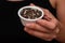 Bowl of Whole Peppercorns in a Female Hand. Gently holding a ramekin filled with assorted whole peppercorns