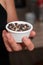 Bowl of Whole Peppercorns in a Female Hand. Gently holding a ramekin filled with assorted whole peppercorns