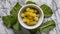 A bowl of yellow flowers with green leaves