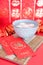 A bowl of Yuanxiao and hongbao in red background. The Chinese characters in the picture mean `happiness` and `good luck`