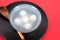 A bowl of Yuanxiao or Tangyuan and spoon in a black tray on a red background