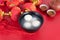 A bowl of Yuanxiao or Tangyuan and tea on a festive red background