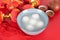 A bowl of Yuanxiao or Tangyuan and tea on a festive red background