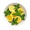 Bowl Zesty Yellow Base, Lemon Zest, Ginger Slices, Mint Leaves On White Plate On A White Background