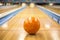 Bowling ball sitting in a colorful bowling alley lane