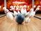 Bowling strike concept with rolling ball and pins. 3D illustration