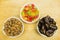 Bowls with additions to cakes and desserts: dried dates, candied pineapple and shelled almonds. View from above.