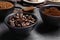 Bowls of beans, instant and ground coffee on grey table, closeup