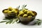 Bowls containing olives and adorned with rustic olive branch twigs on white