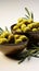 Bowls containing olives and adorned with rustic olive branch twigs on white