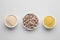 Bowls with different types of brewer`s yeast on light grey background, top view