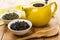 Bowls with dry green and black tea, teapot, spoon