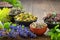 Bowls of dry medicinal herbs - mistletoe, wild marjoram, heather. Calendula flowers, bilberry twigs and bugleherb flowers.