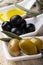 In the bowls extra virgin olive oil and organic olives