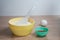 Bowls of flour and cocoa stand on the kitchen table, in the background an egg