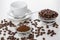 Bowls with ground coffee, coffee beans, empty cup, spoon