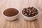 Bowls with ground coffee and roasted coffee beans on table