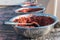 Bowls of ground red pepper drying on a building rooftop