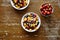 Bowls of healthy organic muesli with fruits on dark wooden table