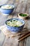 Bowls of noodles on a wooden table, garnished with green onion.