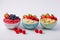 Bowls of oatmeal with berries and fruits on white background. Generative AI