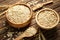 Bowls with oatmeal flakes on wooden table