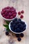 Bowls overflowing with summer berries like raspberries and blackberries.